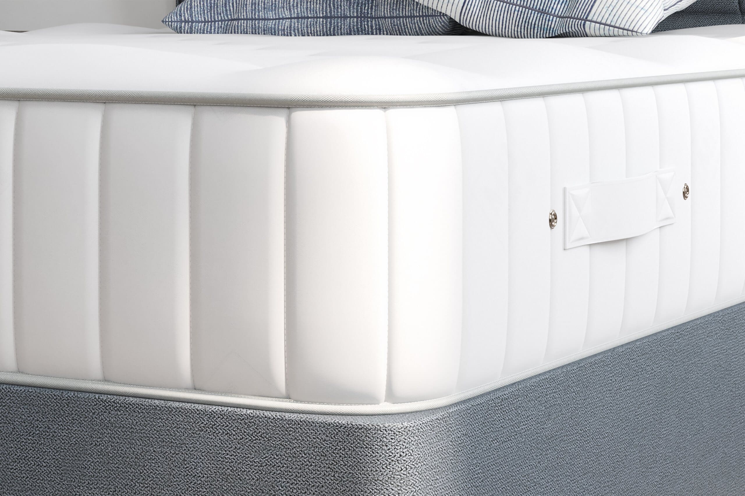 Close up of the corner of the Millbrook Duke Silk Mattress on a grey divan bed base.