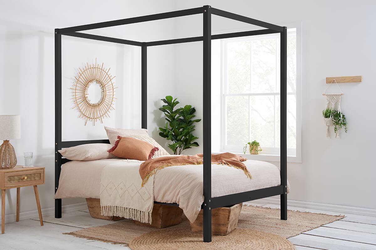Lifestyle image of the Birlea Mercia Black Four Poster Bed with boho light bedding.