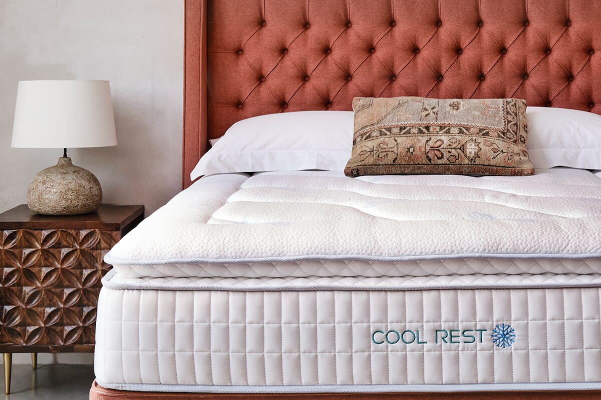 Close up of a Sleepeezee pillow top cooling gel mattress on an orange bed frame.