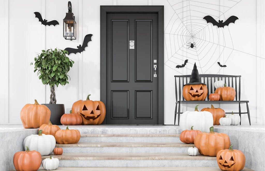 A front door decorated with pumpkins and bats and other Halloween decorations