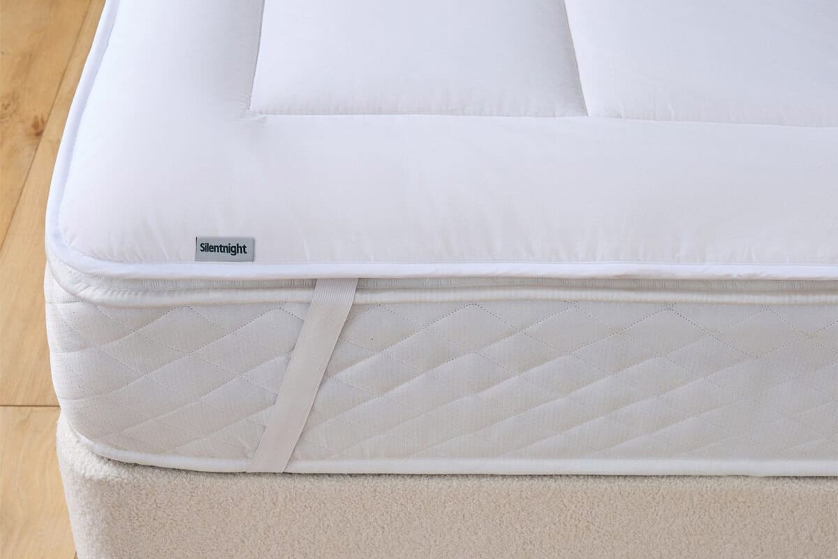 Corner of the silentnight wool mattress topper on a mattress.