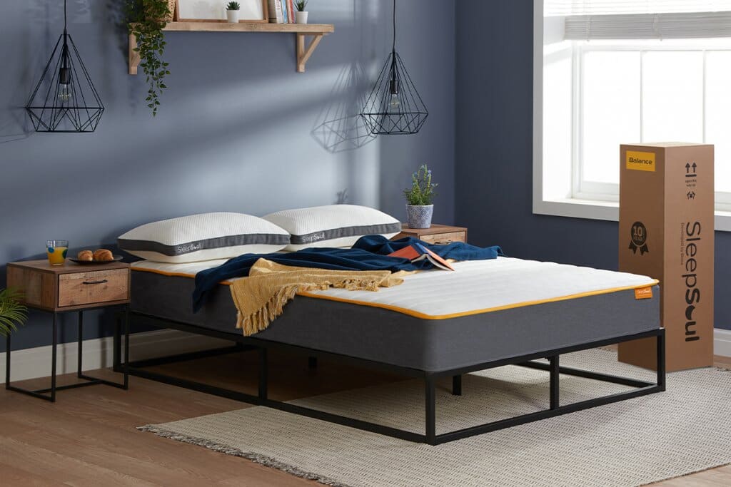 A black bed frame with a SleepSoul Balance 800 Pocket Memory Mattress on top in a modern bedroom