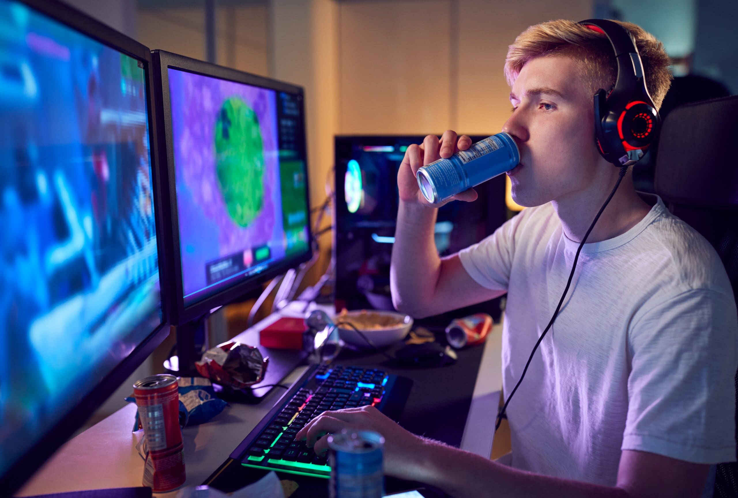 Teenage boy pulling an all nighter playing video games and drinking energy drinks.