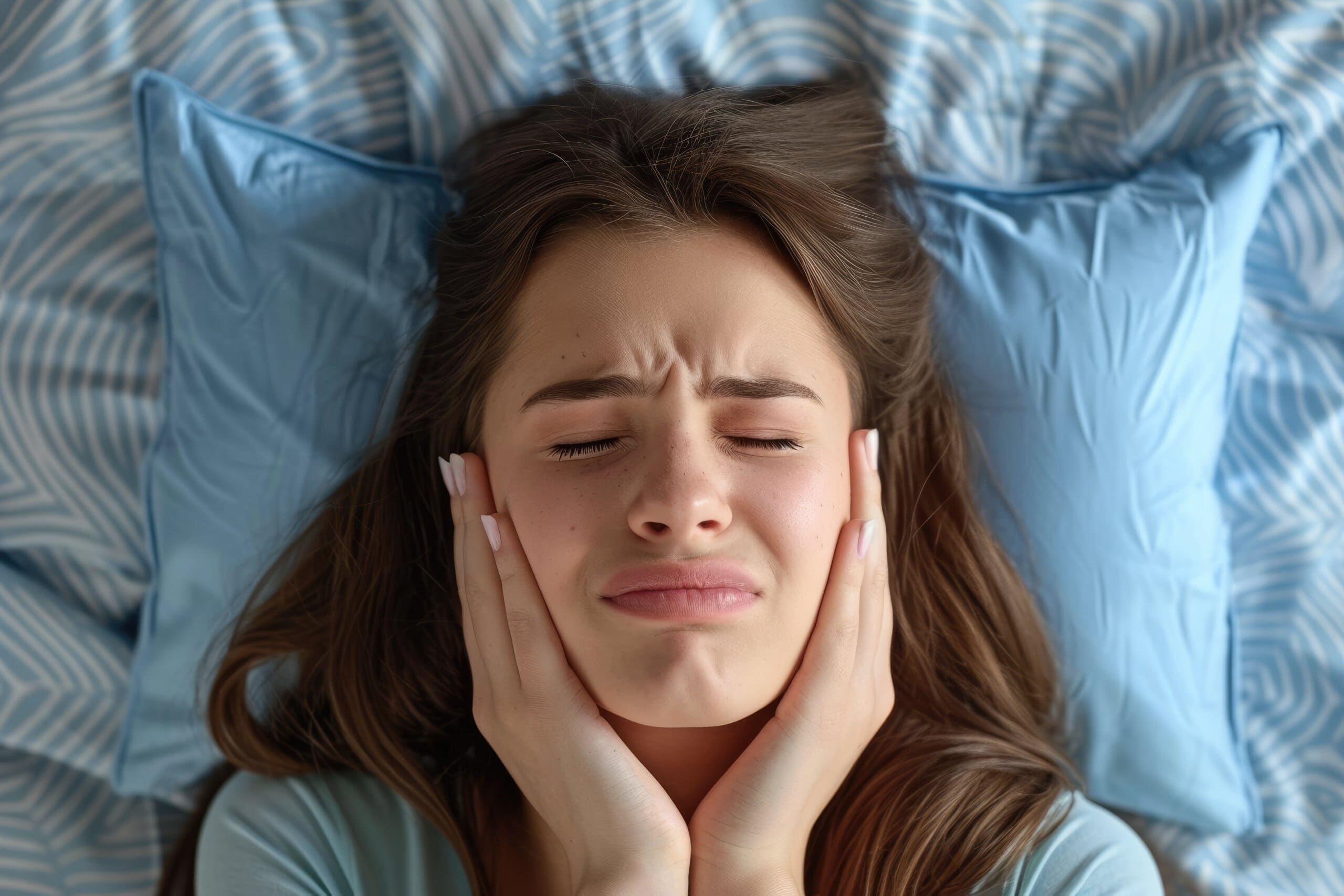 Woman with jaw pain in bed.