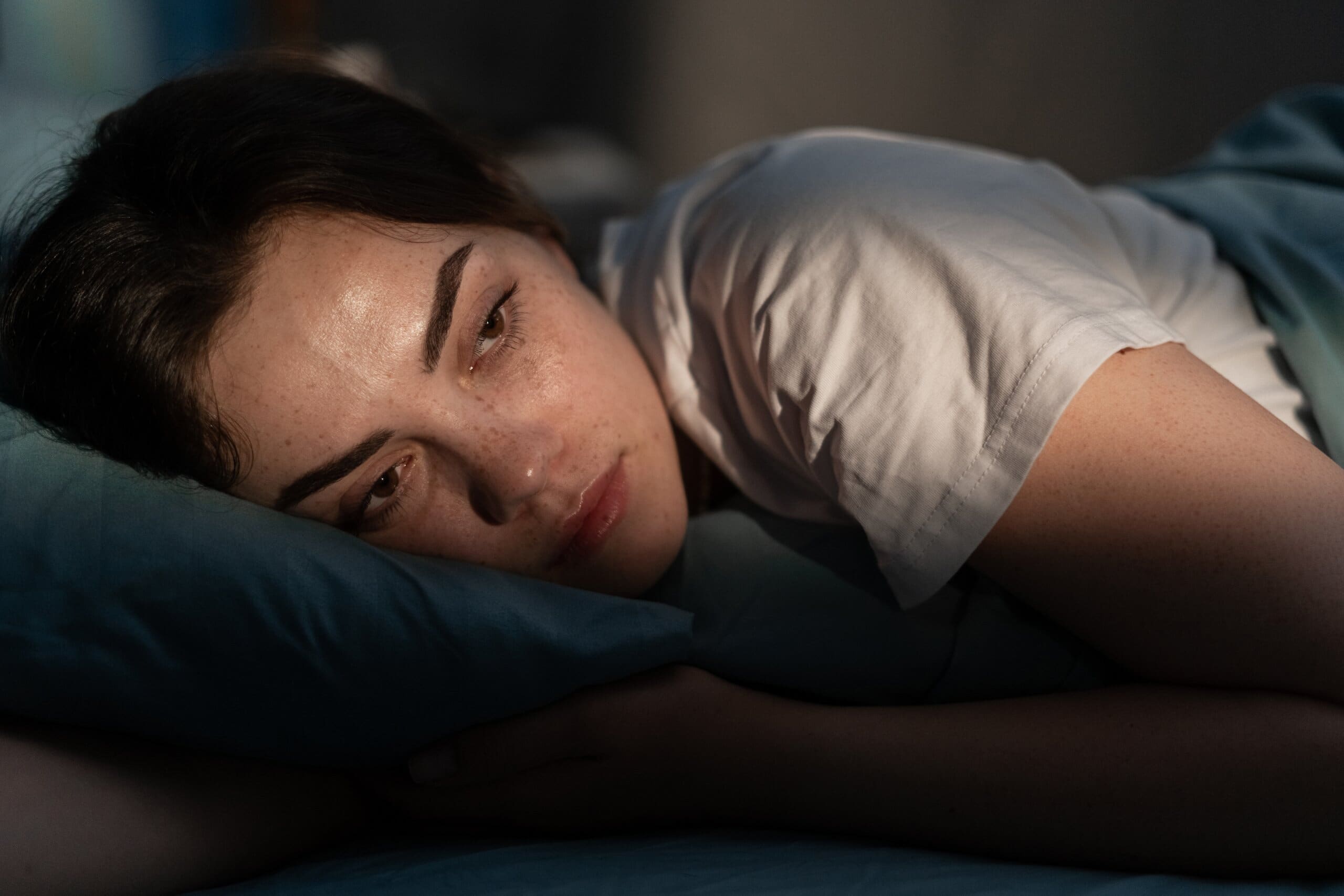 Woman laying awake in bed.