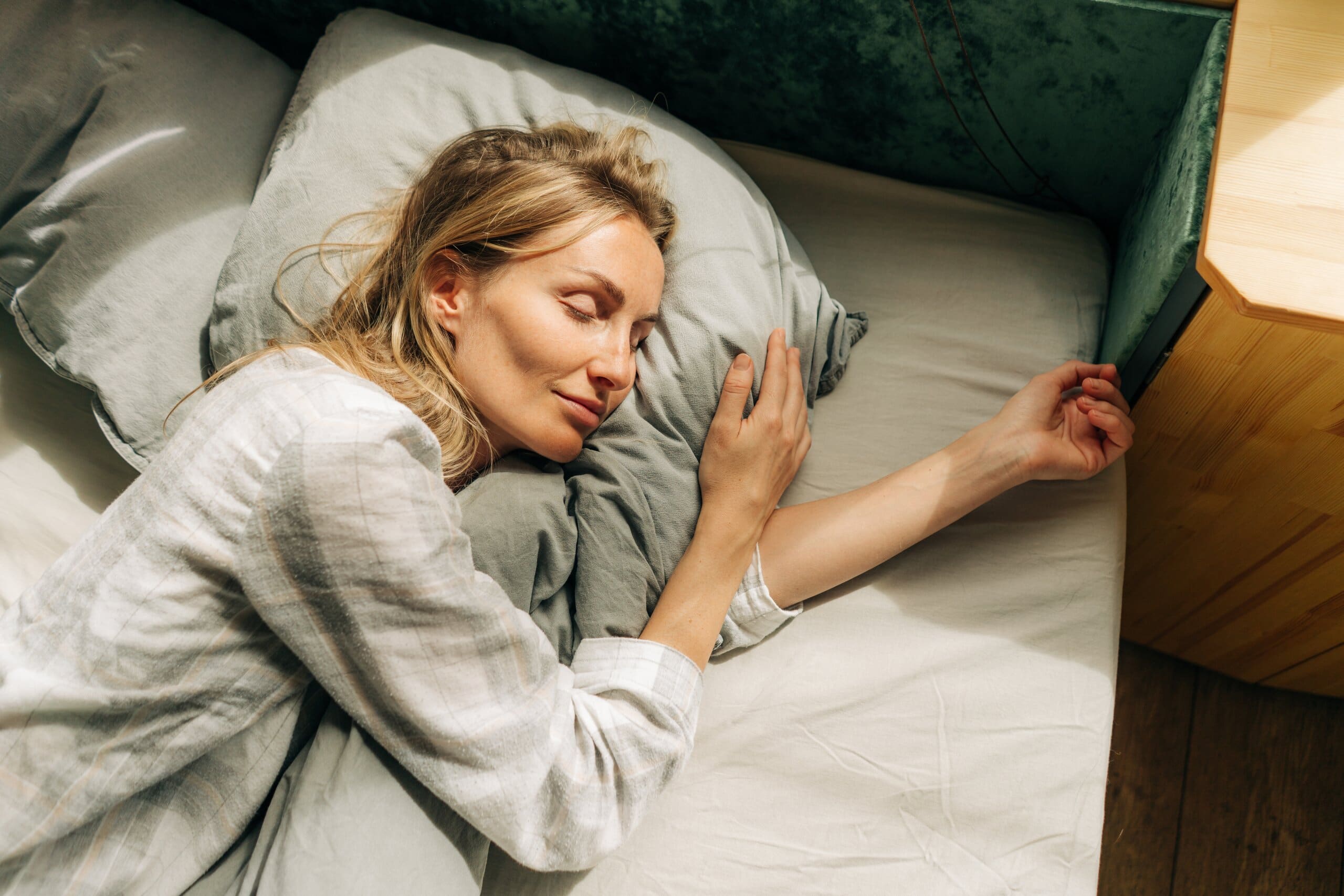 Woman sleeping peacefully in a cool bed.