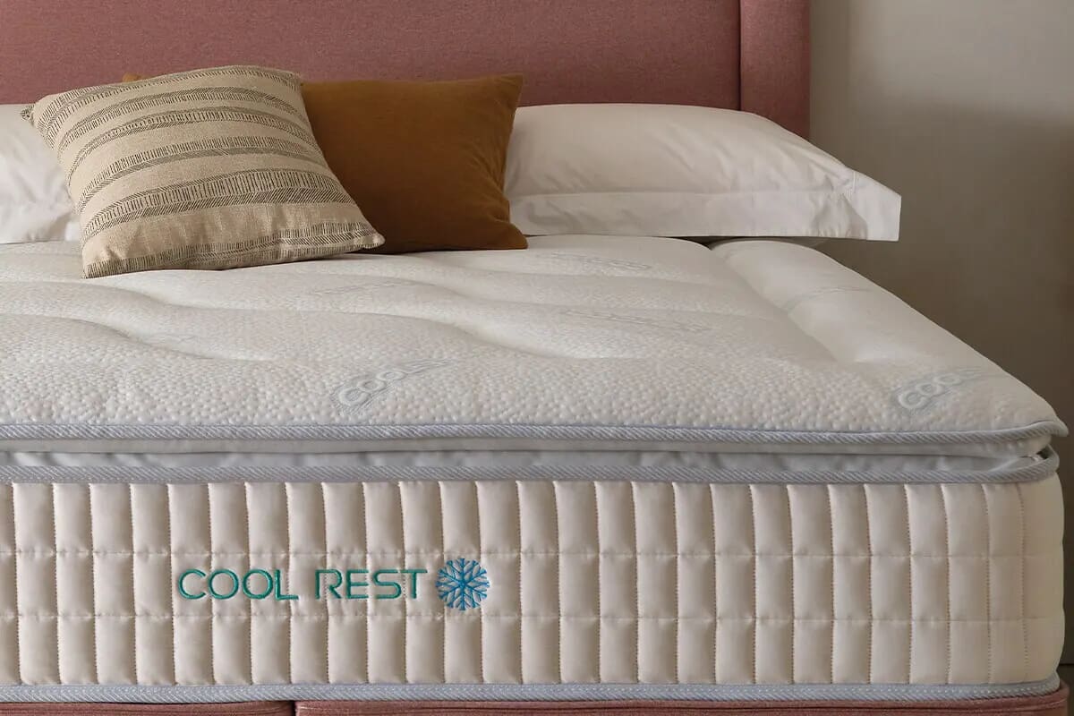 Image of the cool rest mattress from sleepeezee, with purple and brown pillows at the top.