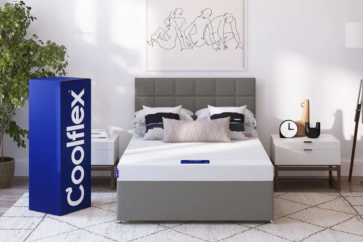 The Coolflex essentials foam mattress on a grey divan with modern white decor and the mattress box next to it.