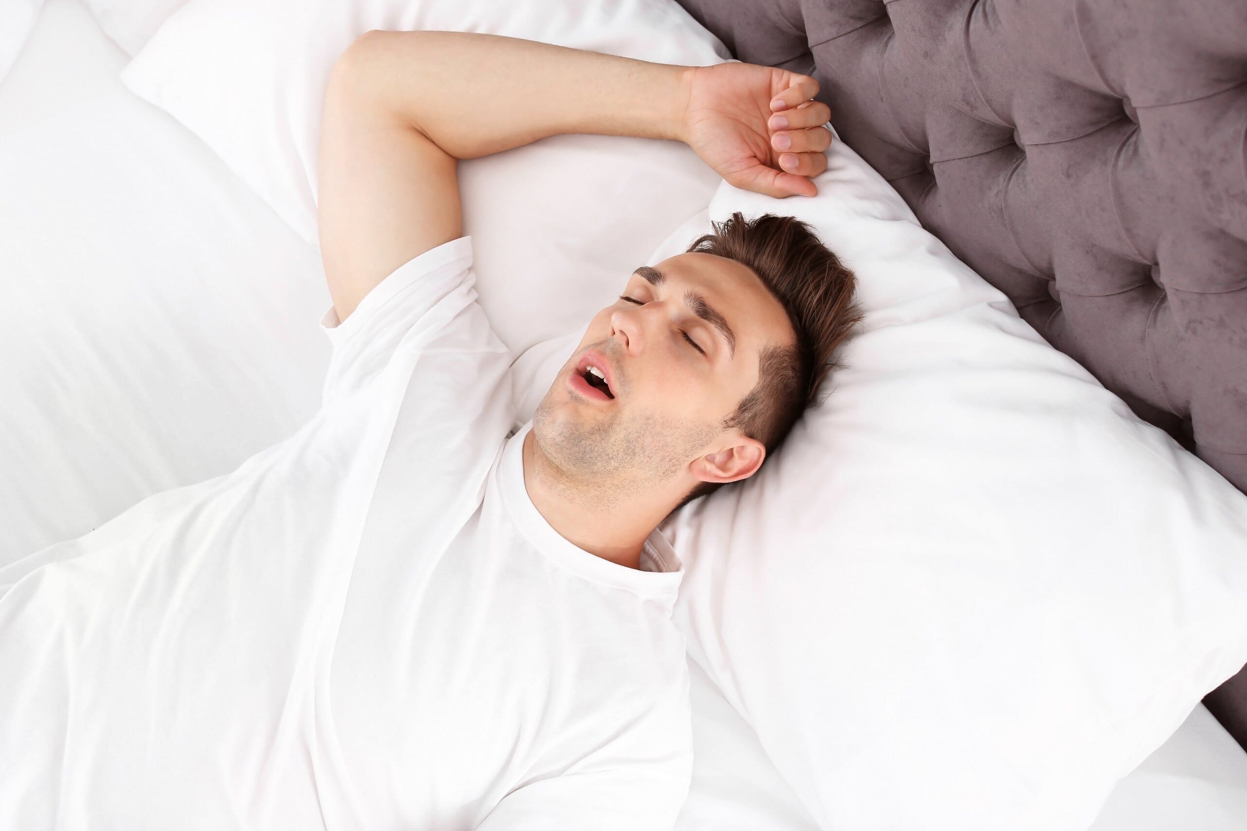 Man sleeping on his back with his mouth open.