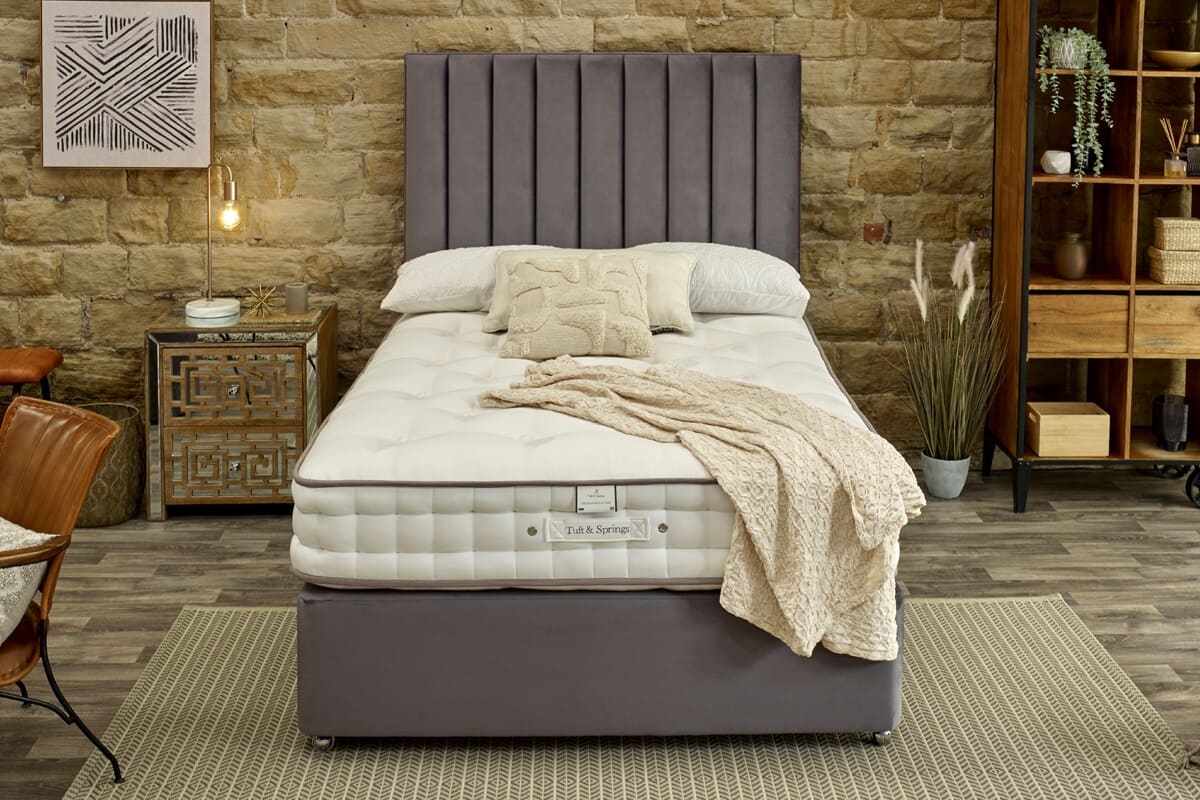 Image of the Tuft & Springs™ Enchantment 1500 Mattress on a grey divan bed in a rustic bedroom.