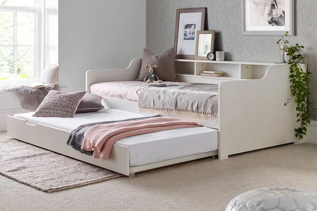 Image of a children's single guest bed with pull out trundle with pink and neutral decor.