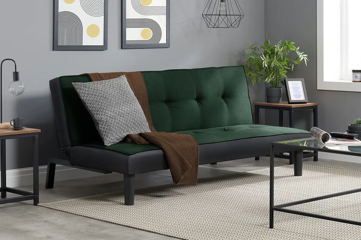 Image of a dark green sofa bed with modern decor surrounding it.