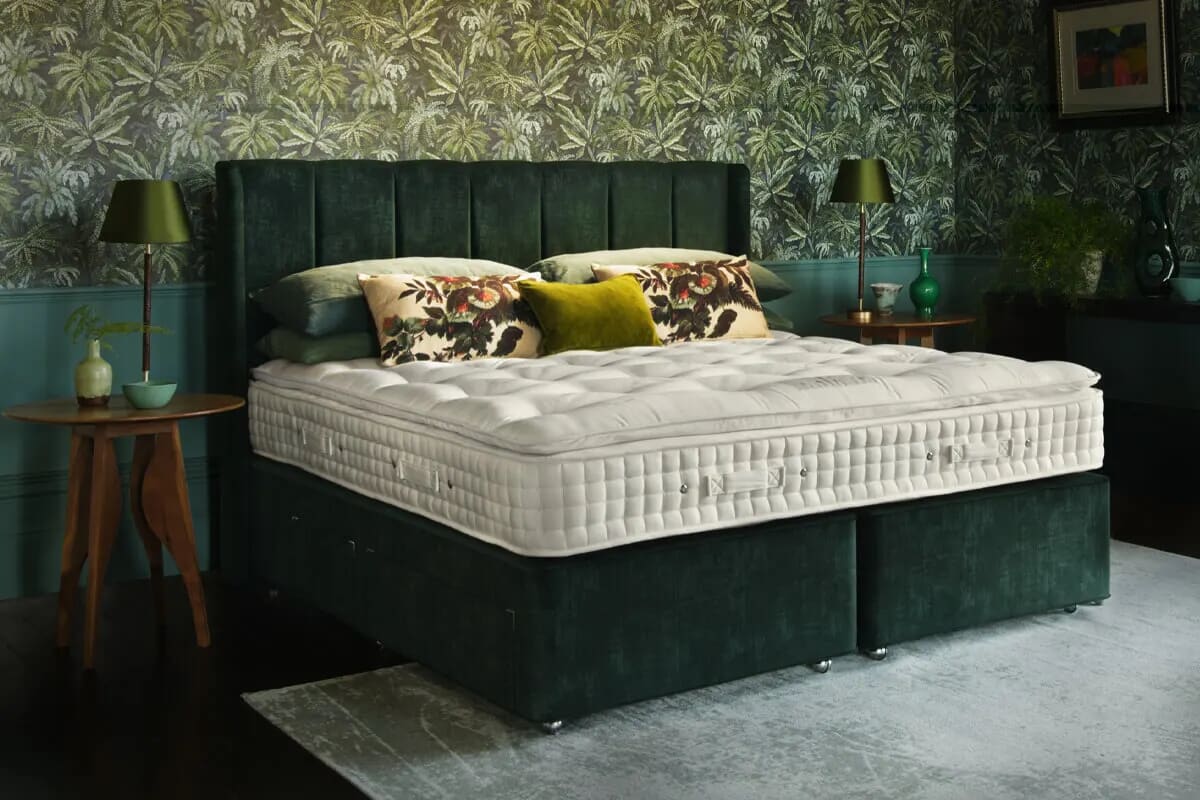 The hypnos elite mattress on a super king size dark green divan in a luxury bedroom.