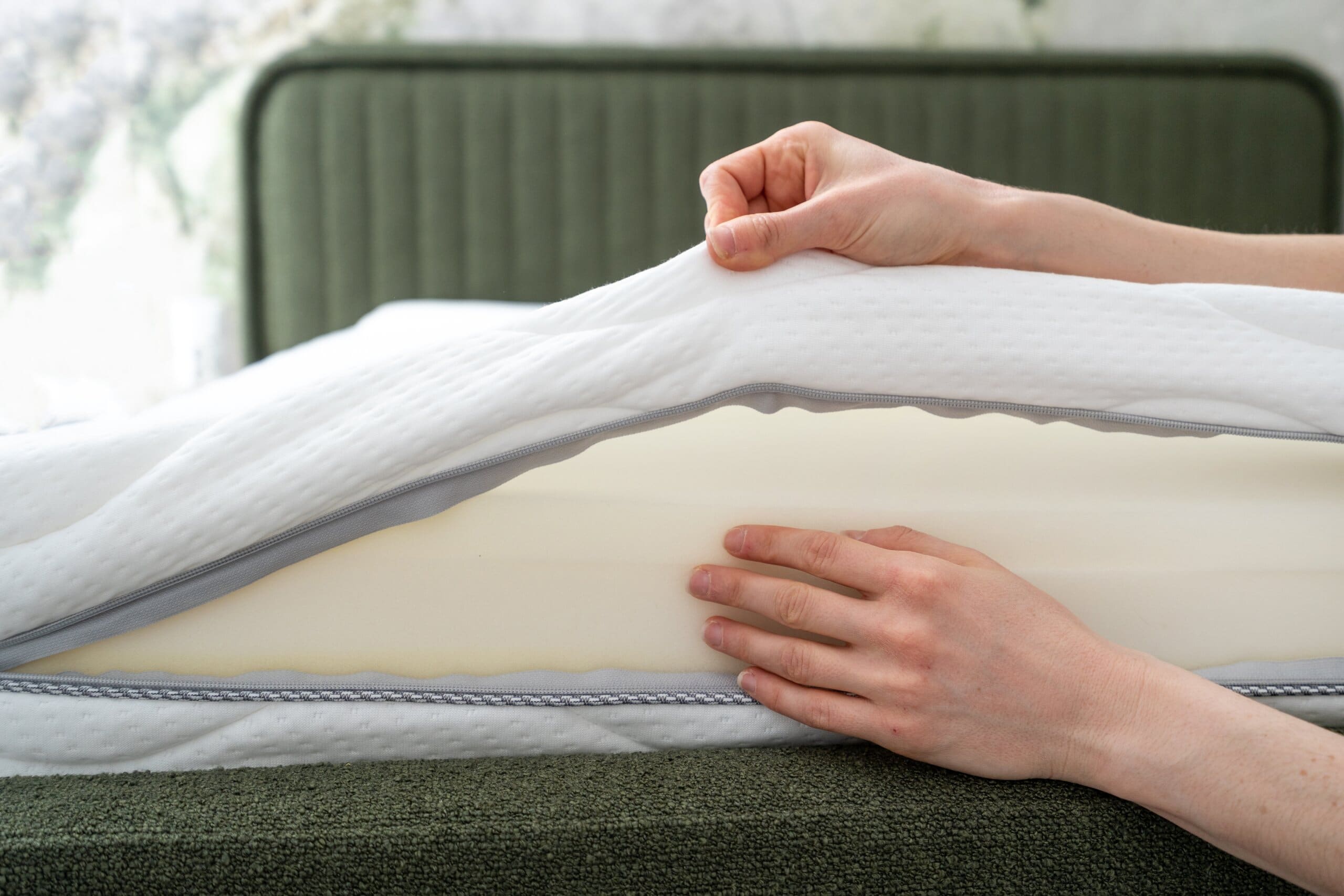 Close up of woman's hands checking the inside of a memory foam mattress.