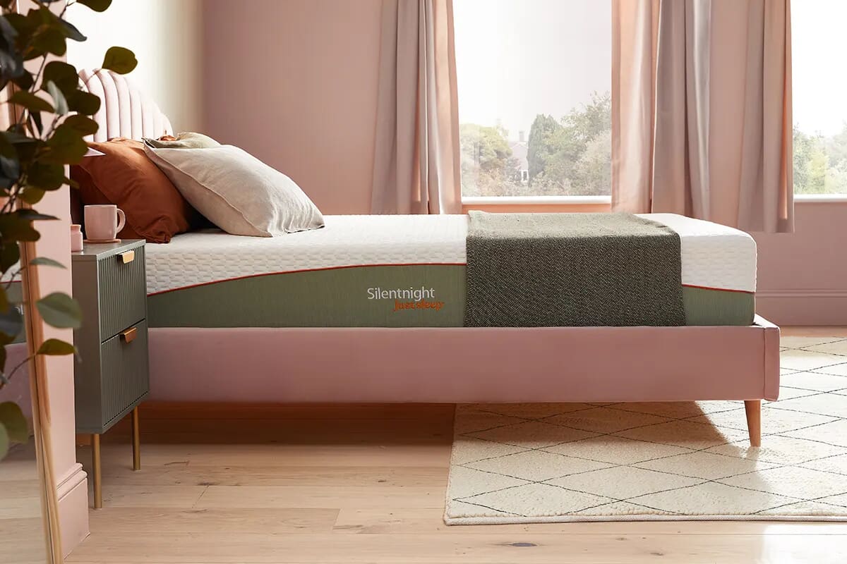 Side image of the Silentnight Just Sleep Mattress on a pink bed frame.