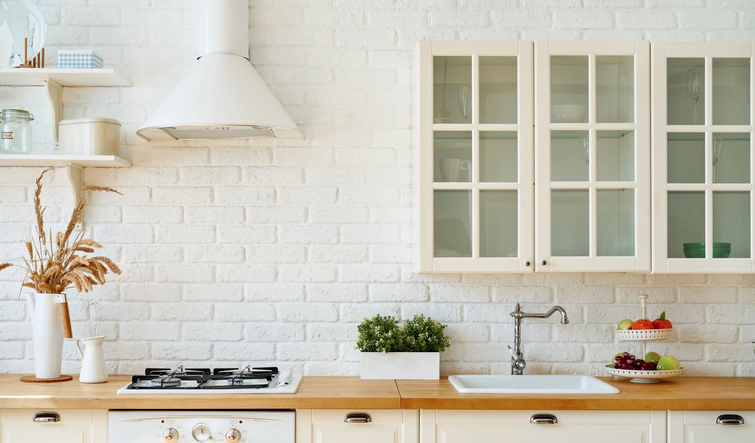 White kitchen interior with painted exposed brickwork.