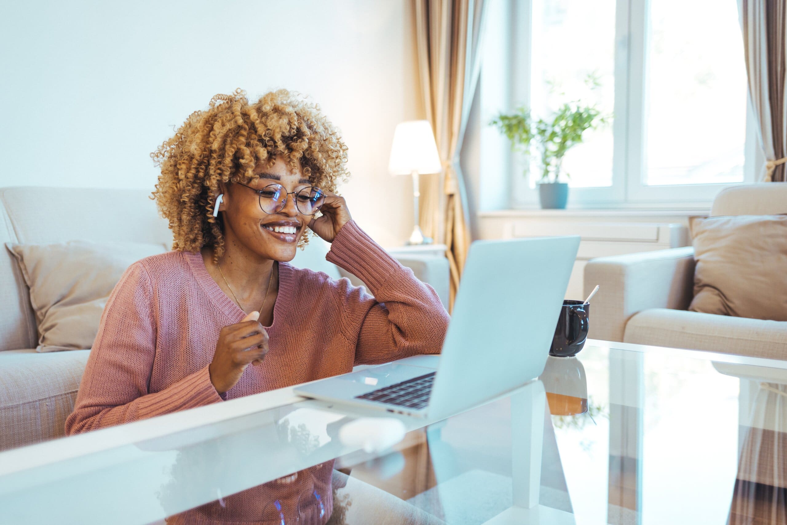 Woman smiling at laptop. Side hustle.