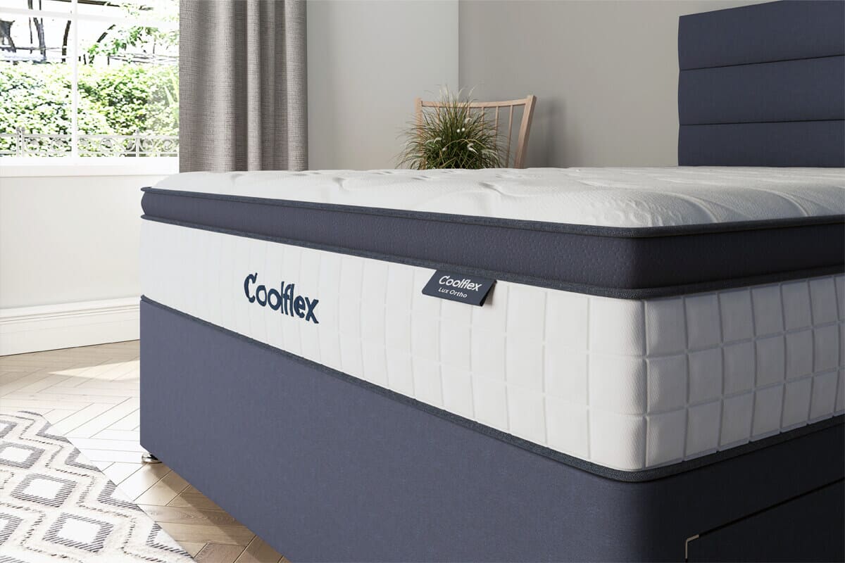 Image of the lux ortho mattress on a grey divan base.