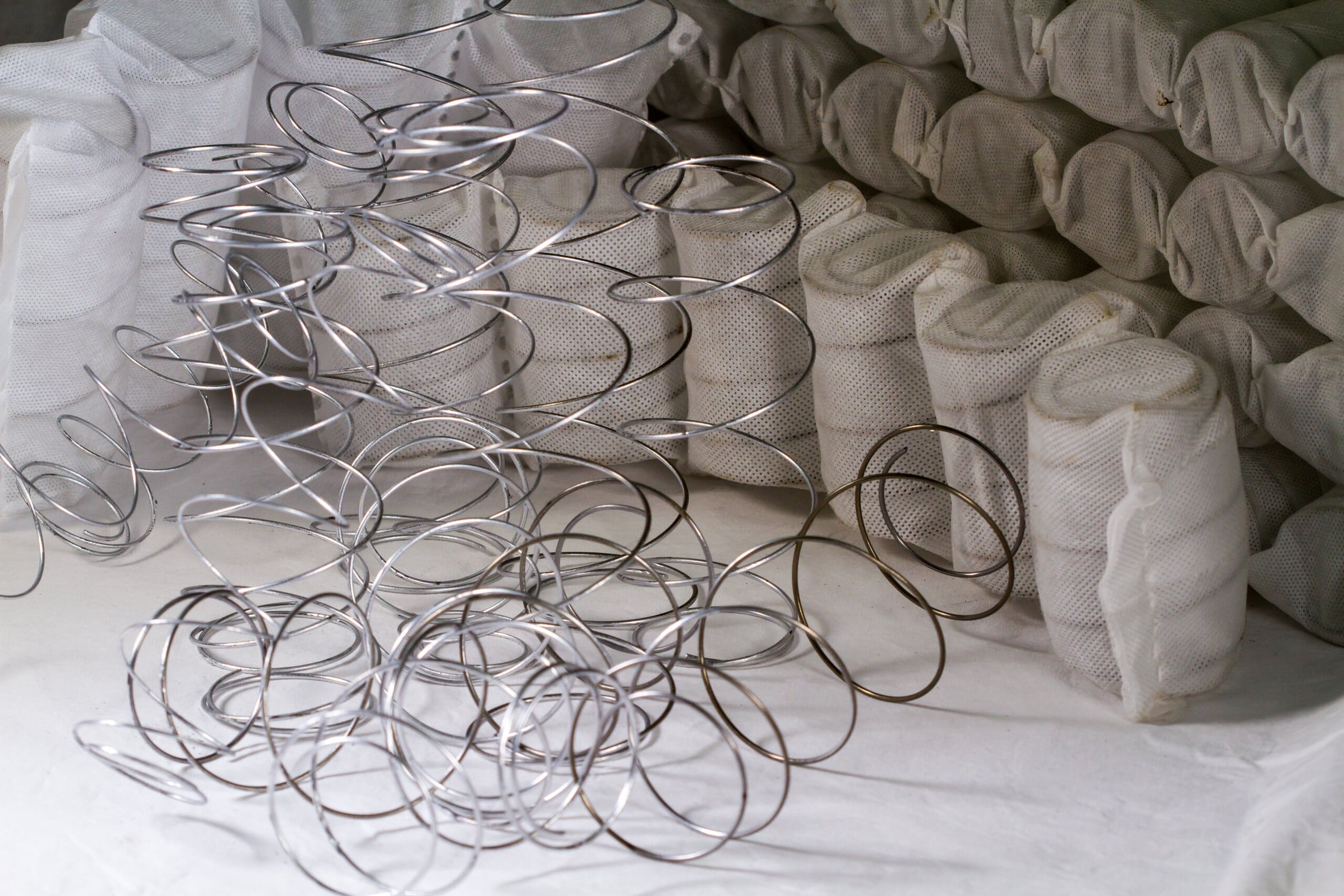 Mattress springs in a pile next to pocket springs.