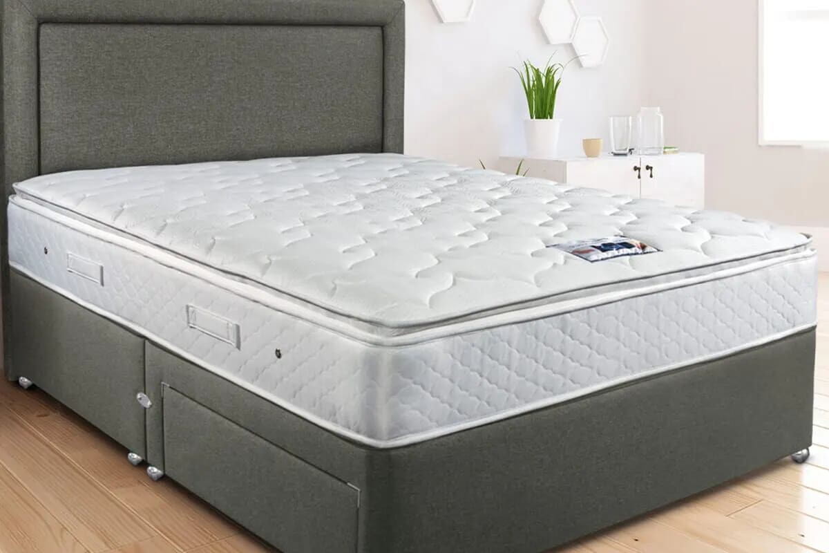 An image of a white mattress on a divan bed, with a pillow top so clearly can't be flipped.