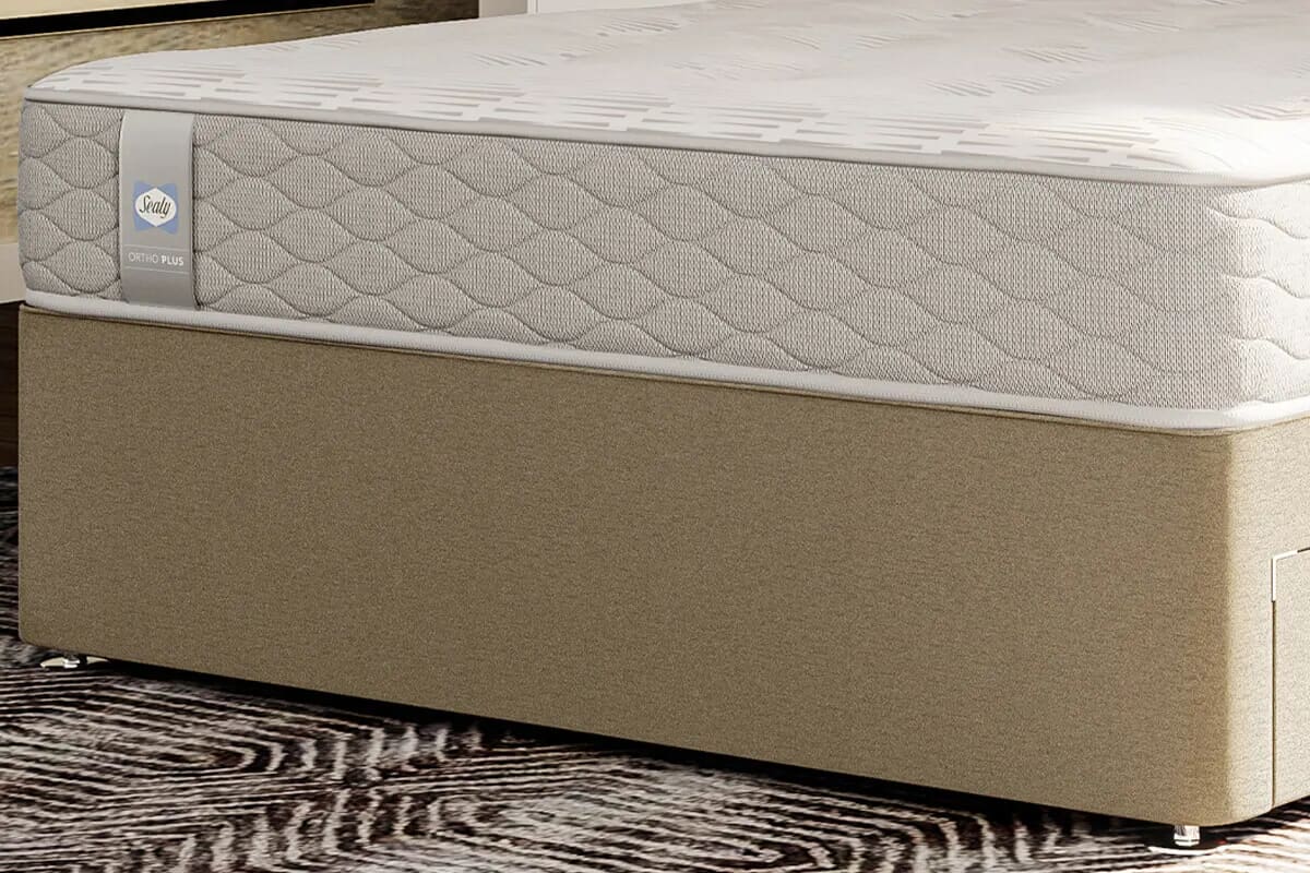 Close up of the bottom of the sealy ortho plus silver on a taupe divan base.