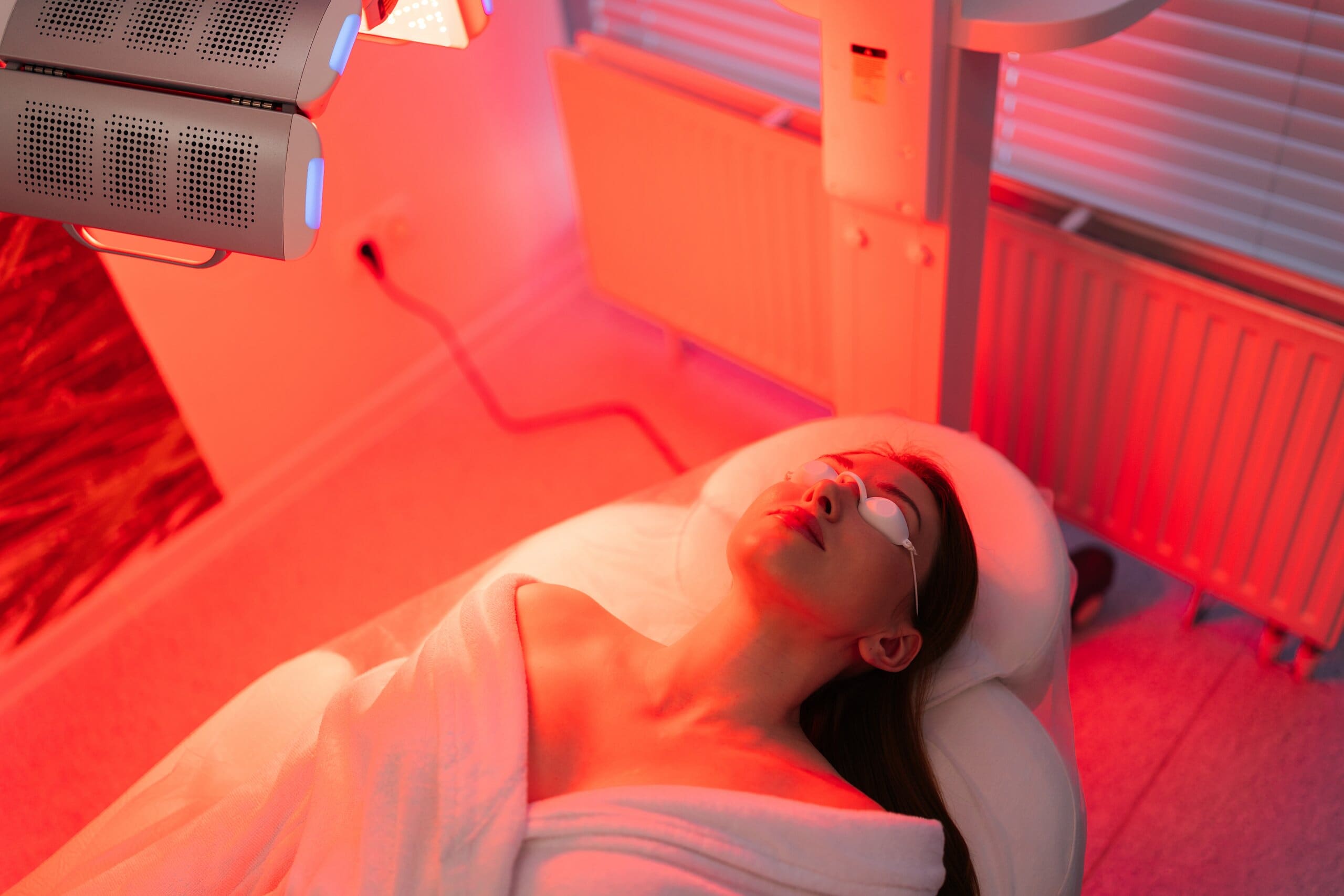 Woman using light therapy in a spa setting.