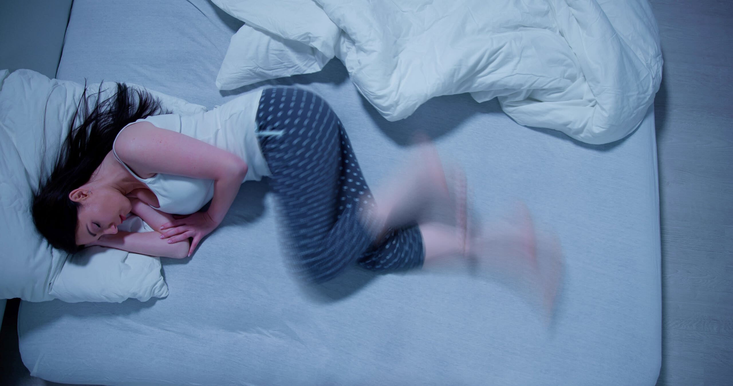 Woman sleeping on her side suffering from restless legs.