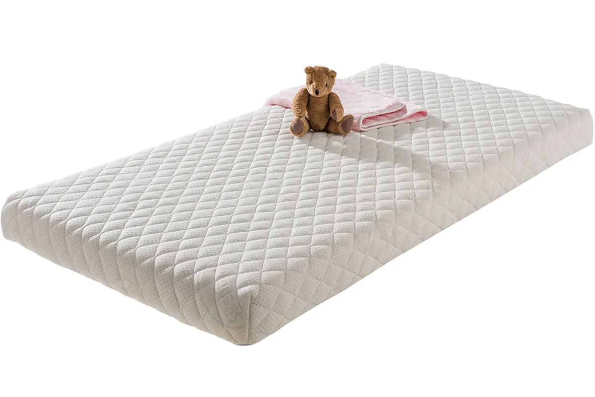 Image of the safe nights superior mattress on a white background with a teddy bear on it.