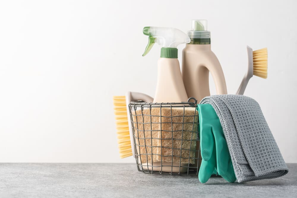 Basket with cleaning detergents and cloths. 