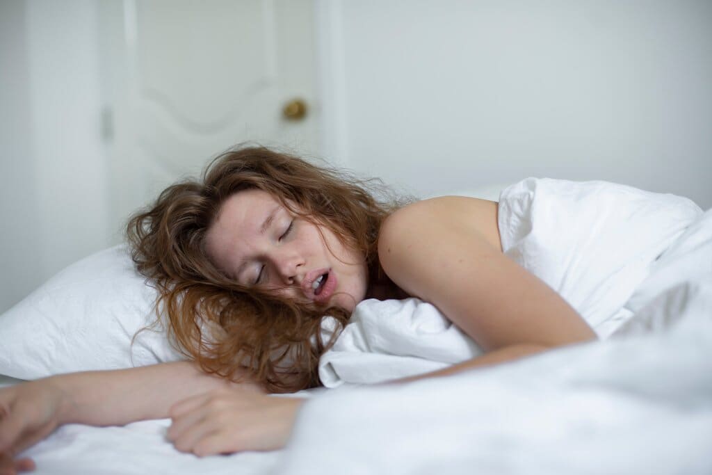 Girl sleeping snoring in bed.