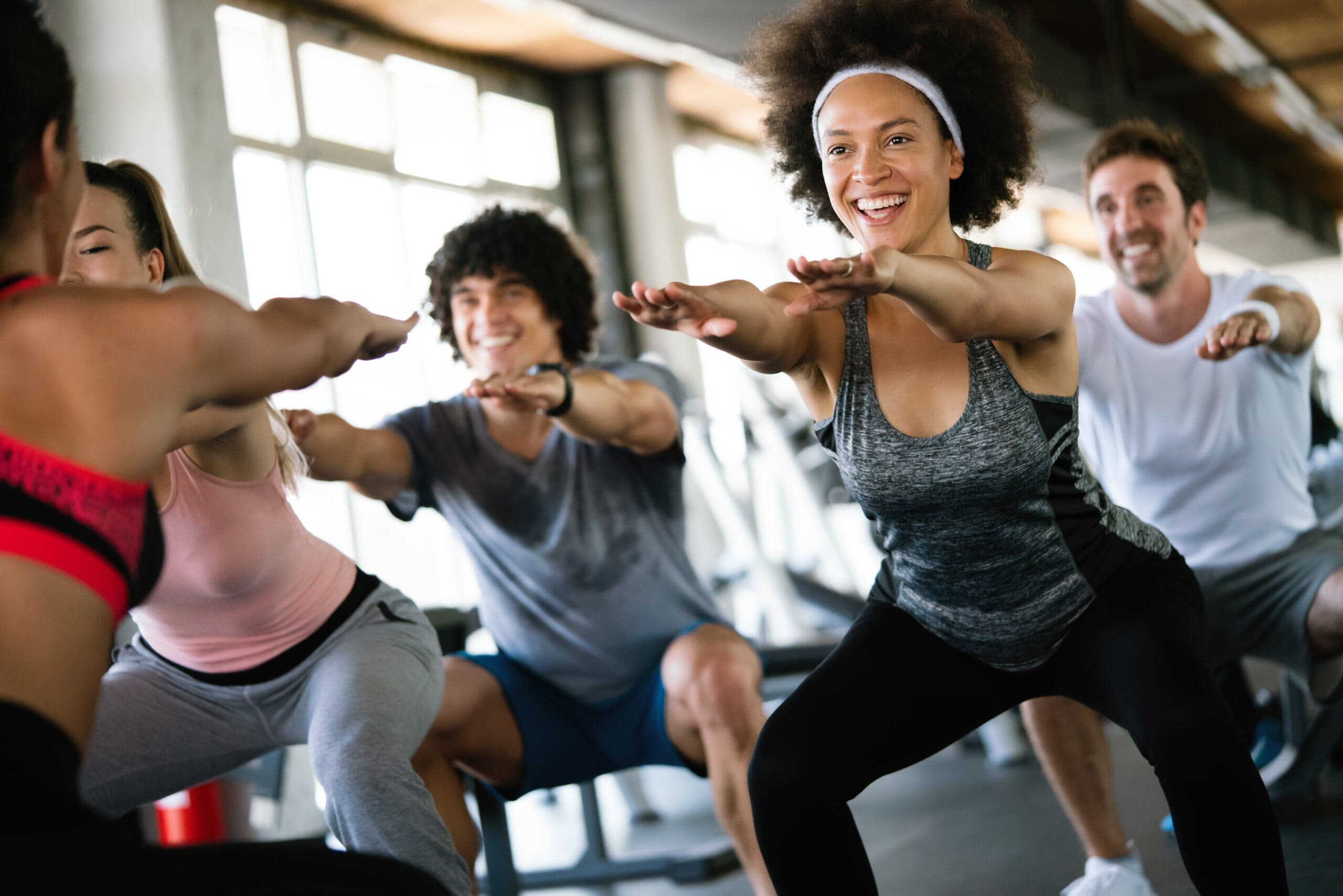 Group of people in the gym doing squats.