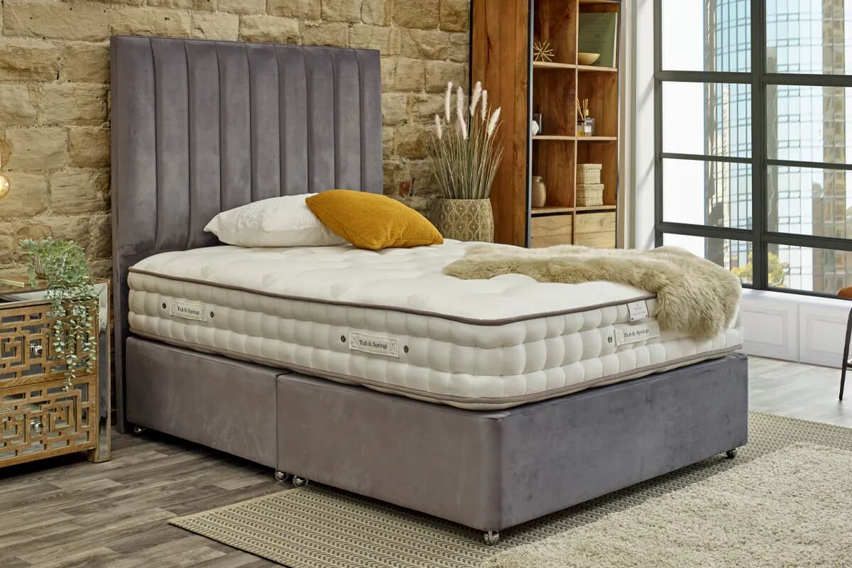 Luxury mattress on a grey divan bed with yellow decor.