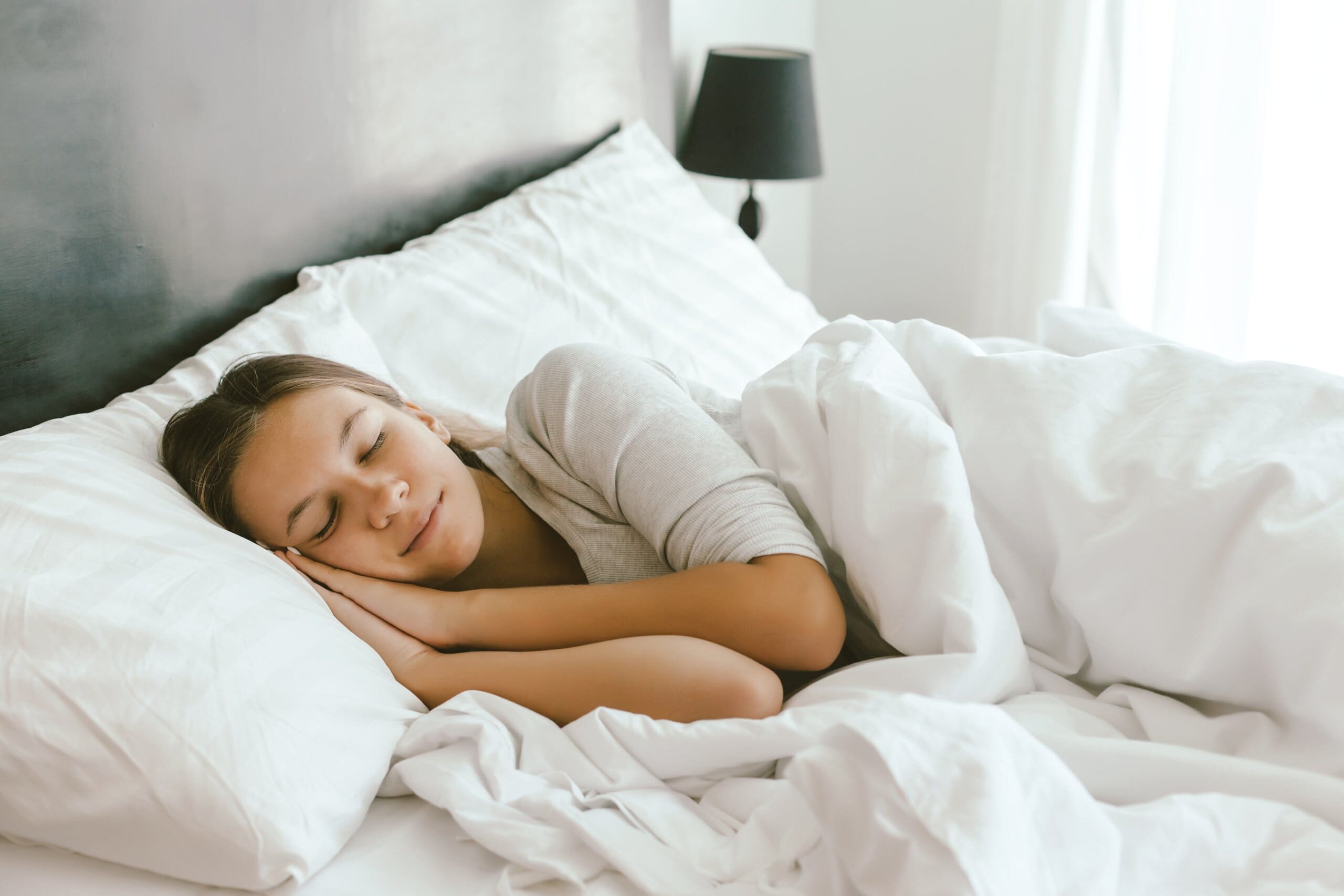 Woman sleeping peacefully in comfy bed.