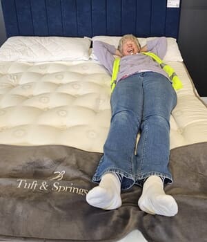 Deb standing beside a bed.