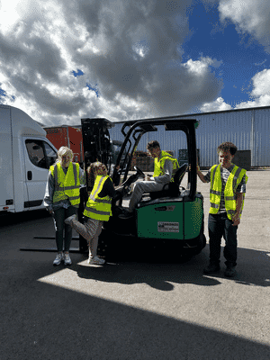 Fifth trust posing with the forklift.